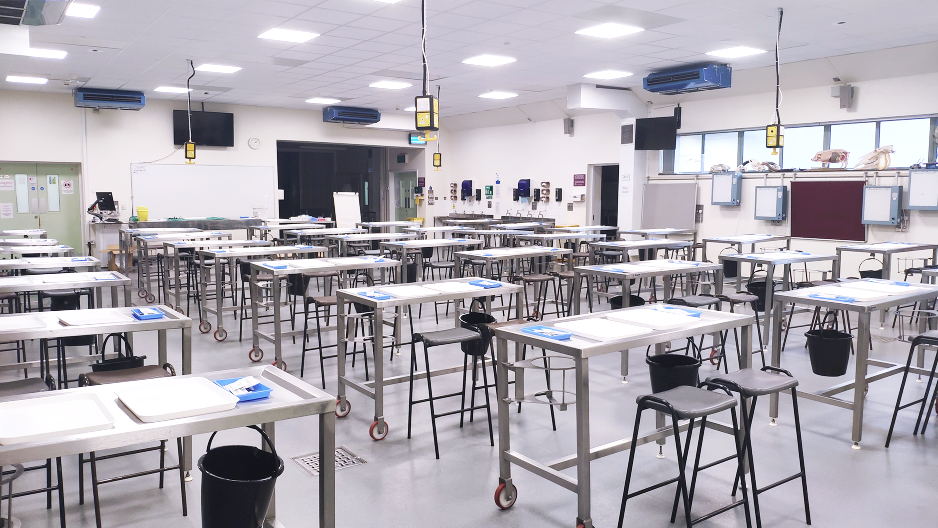 several stainless steel dissecting tables in a large room